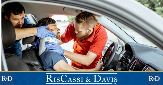 Man with neckbrace in car being rescued by paramedics