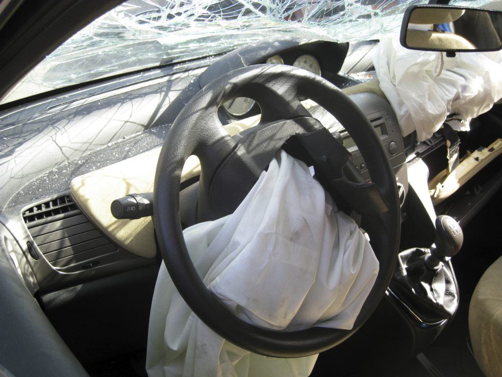 smashed car windshield and deployed airbag