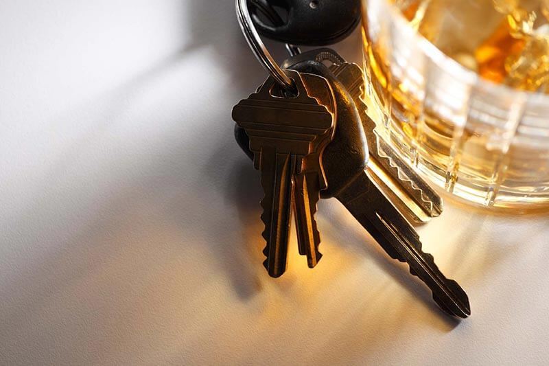 A set of keys beside a glass of wine