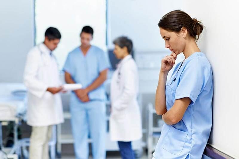 Nurse Thinking of Something by the Corridor