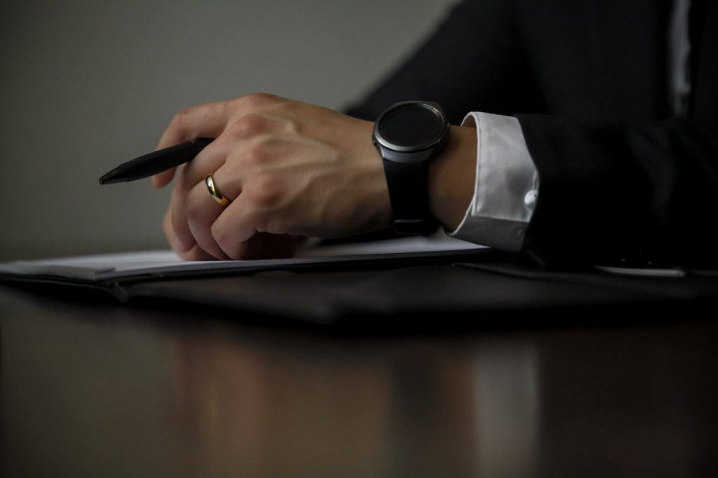 Hands Holding a Pen on a Journal