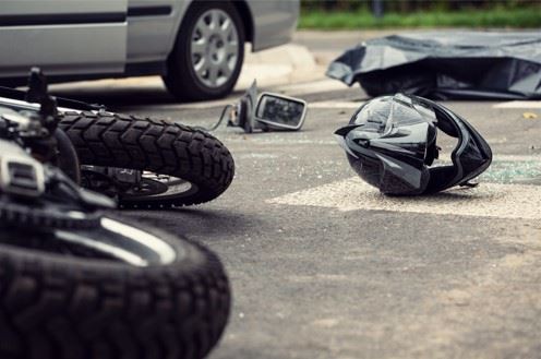 crashed motorcycle and helmet laying in road